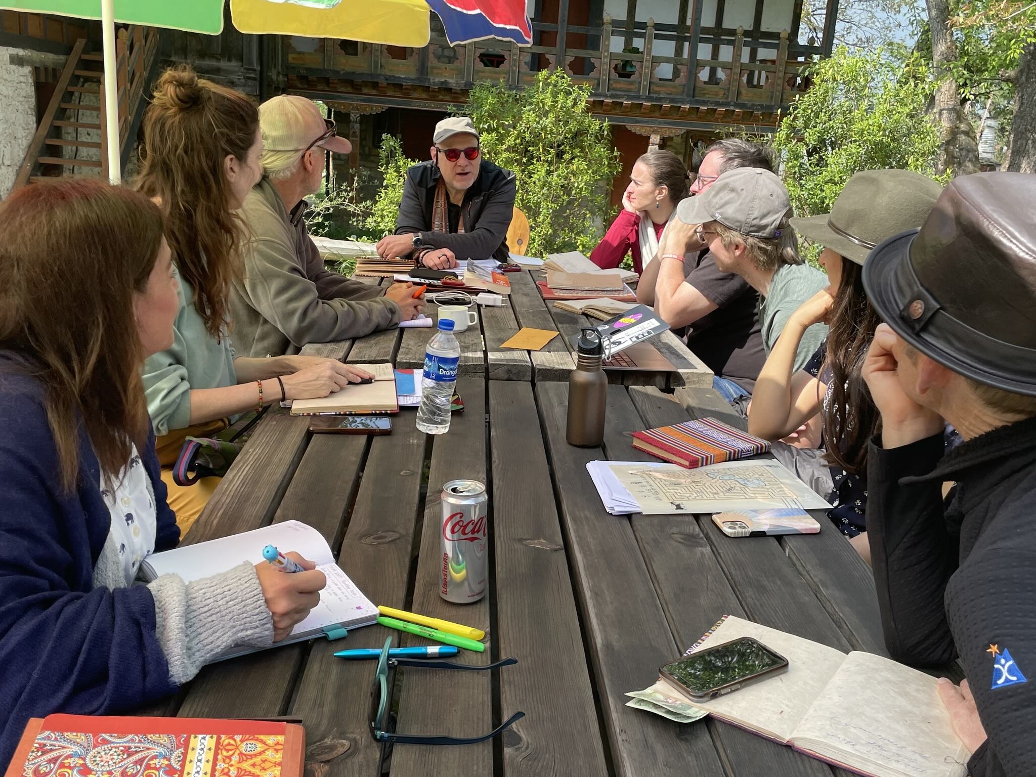 Travelers gathered around an outdoor table with a trip expert