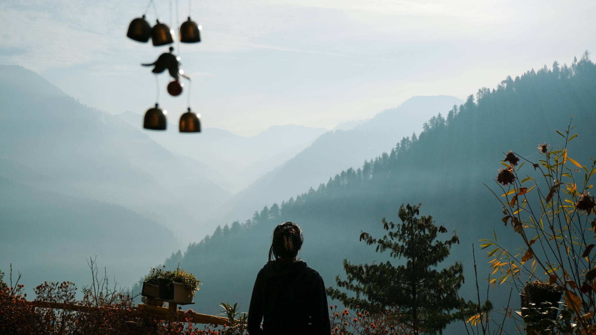 Traveler looking toward misty mountain ridges