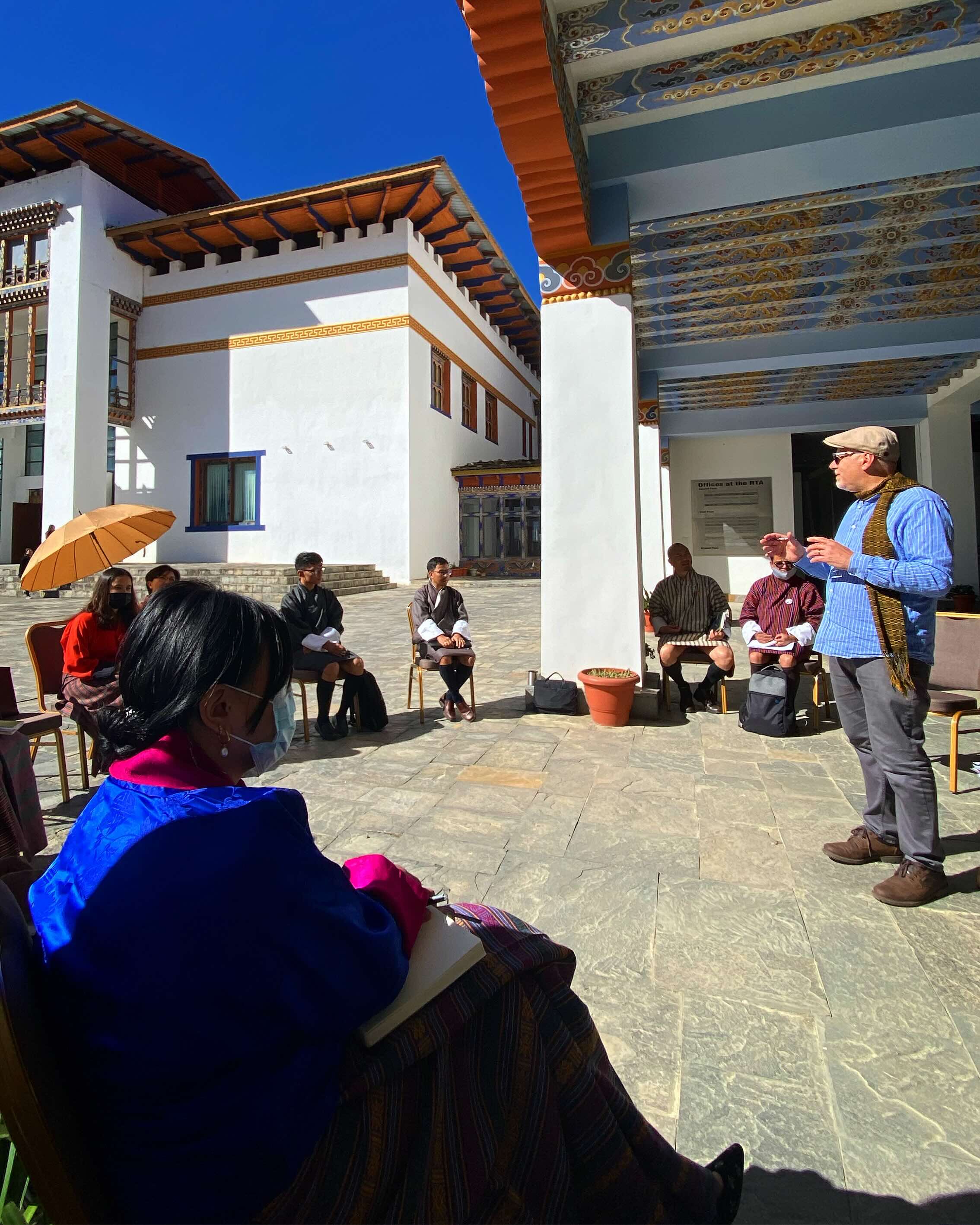 Small group listening to a guide in a courtyard